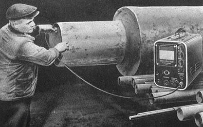 一位戴帽子的男子將探頭插入大型管道中進行檢查，旁邊有超聲波設(shè)備。